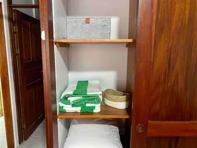 a book shelf with towels and a box on it at El Papagayo Verde 5 min walk to the beach and downtown in Coco