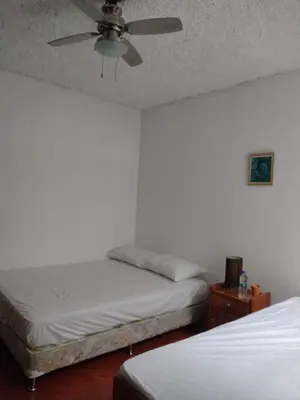 a bedroom with two beds and a ceiling fan at Casa #4 Studios in San Pedro