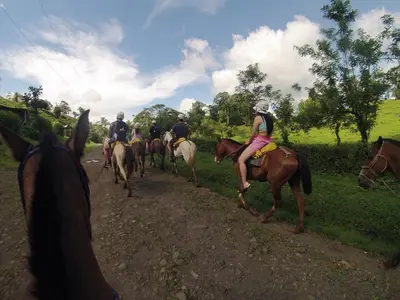 a group of people riding horses down a dirt road at Modern Villa Exclusive Tropical Nature Retreat Rio Celeste 6 to 8 Guests in Upala