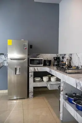 a kitchen with a stainless steel refrigerator at Malani Lodge Tamarindo in Villarreal