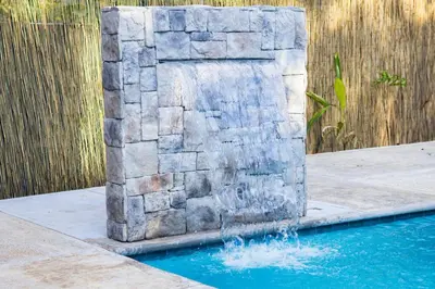 a water fountain in the middle of a swimming pool at Malani Lodge Tamarindo in Villarreal