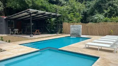 a swimming pool in a backyard with a pergola at Malani Lodge Tamarindo in Villarreal