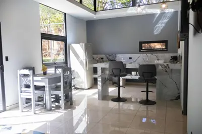 a dining room with a white table and chairs at Malani Lodge Tamarindo in Villarreal