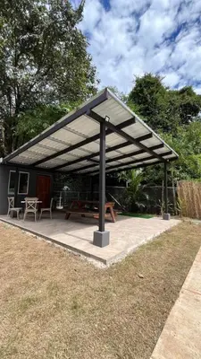 a pavilion with a picnic table and a picnic bench at Malani Lodge Tamarindo in Villarreal