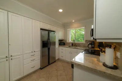 a kitchen with white cabinets and a stainless steel refrigerator at Veranda 4B - 3bdr 3bath in La Mona