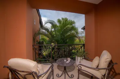 a balcony with chairs and a table and a palm tree at Veranda 6C - 3 bdr 3 bath in La Mona