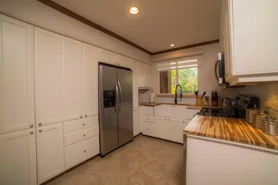 a kitchen with white cabinets and a stainless steel refrigerator at Veranda 6F - 2bdr 2 bth in La Mona