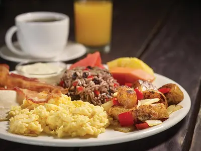 a plate of breakfast food with scrambled eggs and fruit at Veranda 6F - 2bdr 2 bth in La Mona