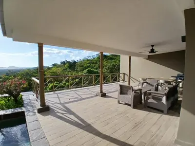 a deck with chairs and a view of the mountains at Luxury villa Potrero in Potrero