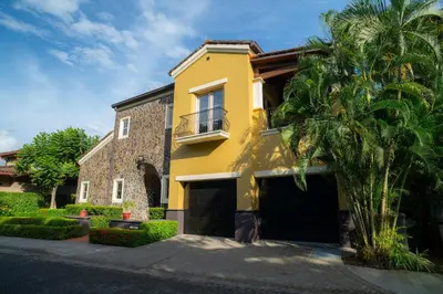 a yellow house with a palm tree in front of it at Villa Angel 4 bdr Ocean View private pool Family in La Mona