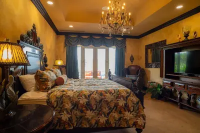 a bedroom with a bed and a couch and a tv at Villa Angel 4 bdr Ocean View private pool Family in La Mona