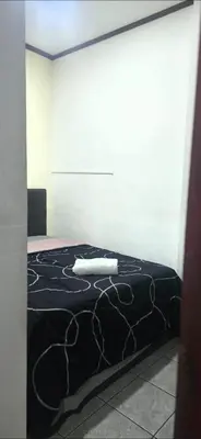 a bedroom with a black bed with a white wall at Apartamentos Adela cerca embajada americana in San José
