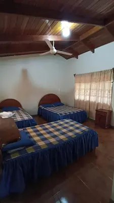 two beds in a room with a ceiling at Hotel El Paraje in Santa Cruz