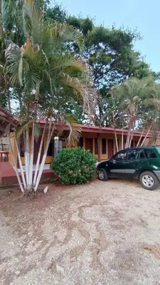 a car parked in front of a house with a palm tree at Hotel El Paraje in Santa Cruz