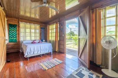 a bedroom with a bed and a window and a fan at Cabañas Retiro Del Rio in Guayabal