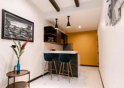 a kitchen with a bar with two blue stools at Aralias Villas in Agua Azul
