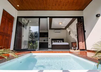 a swimming pool in a house with a bedroom at Aralias Villas in Agua Azul