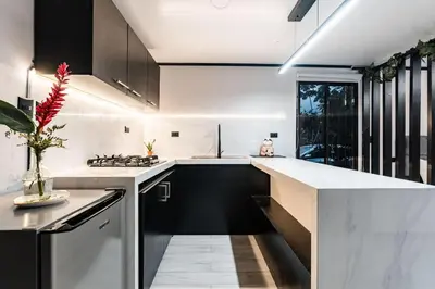 a kitchen with black and white counters and a window at Aralias Villas in Agua Azul