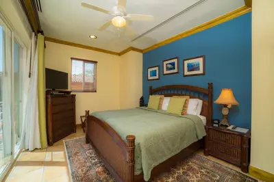 a bedroom with a bed and a ceiling fan at Casa Oasis 5 bdr private pool in La Mona
