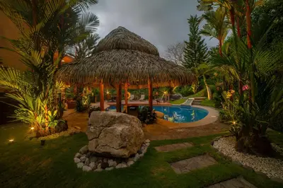 a resort with a large straw hut and a swimming pool at Casa Oasis 5 bdr private pool in La Mona