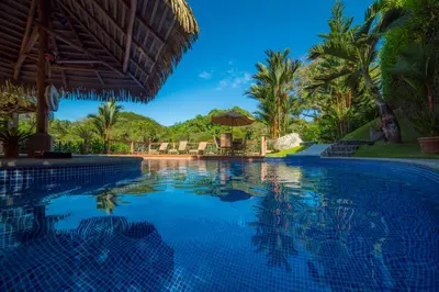 a swimming pool at a resort with palm trees at Casa Oasis 5 bdr private pool in La Mona