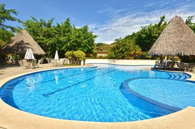 a swimming pool at a resort with chairs and umbrellas at Colina 5D - 3 bdr 2 bath Family in La Mona
