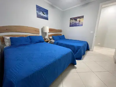 two beds in a room with blue sheets at Sweet fishing apartment in Isla Herradura