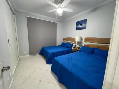 two beds in a room with blue sheets at Sweet fishing apartment in Isla Herradura