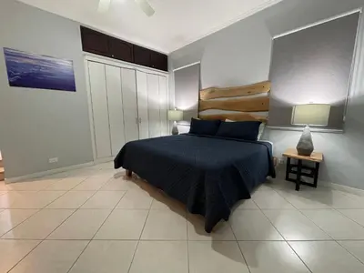 a bedroom with a bed with a blue comforter at Sweet fishing apartment in Isla Herradura
