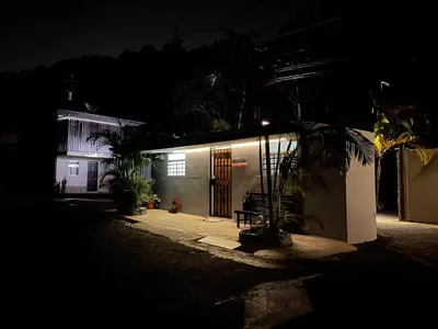 a house at night with a bench in front of it at Donguis Rooms in San Pablo
