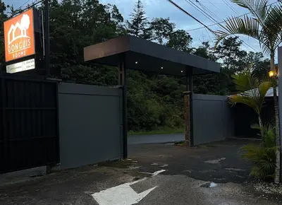 a gas station with a gate and a sign at Donguis Rooms in San Pablo