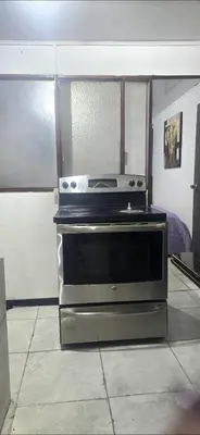 a kitchen with a stove top oven in a room at Rohrmoser a 100 metros de la embajada americana in San José