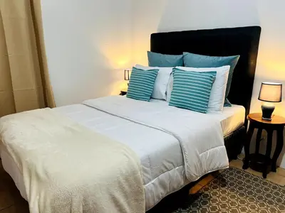 a bedroom with a large bed with blue and white pillows at Alto Cruz Executive Loft in Turrialba