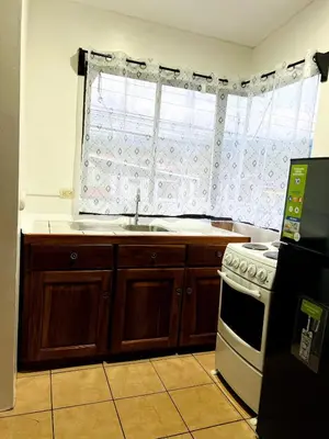 a kitchen with a sink and a stove and a window at Alto Cruz Executive Loft in Turrialba