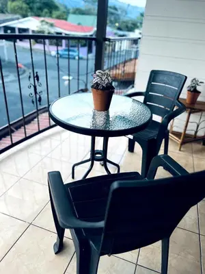 a table with chairs and a potted plant on a balcony at Alto Cruz Executive Loft in Turrialba