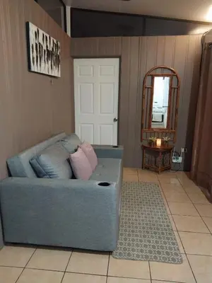 a blue couch in a living room with a mirror at Alto Cruz Executive Loft in Turrialba