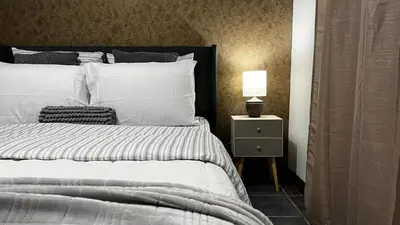 a bedroom with a bed and a lamp on a night stand at Executive Apartment Escazú in Escazu