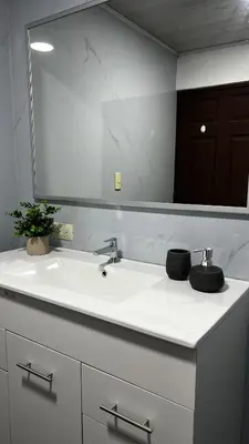 a bathroom with a sink and a large mirror at Executive Apartment Escazú in Escazu