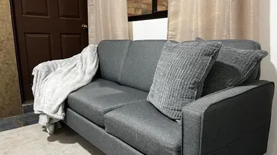 a gray couch with pillows in a living room at Executive Apartment Escazú in Escazu