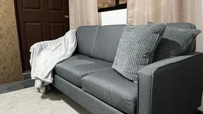 a gray couch sitting in a living room next to a door at Executive Apartment Escazú in Escazu