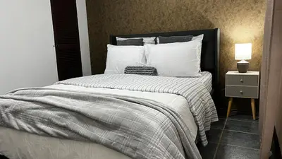 a bedroom with a large bed with white pillows at Executive Apartment Escazú in Escazu