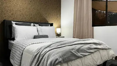 a bedroom with a large bed with white pillows at Executive Apartment Escazú in Escazu