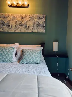a bedroom with a white bed with a head board at Family Nest Turrialba in Turrialba