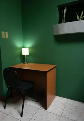 a desk with a chair next to a green wall at Family Nest Turrialba in Turrialba