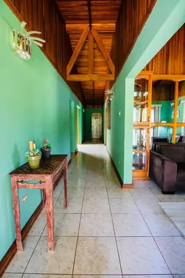 a hallway with green walls and a wooden ceiling at Family Nest Turrialba in Turrialba