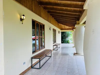 two benches sitting on the side of a building at Family Nest Turrialba in Turrialba