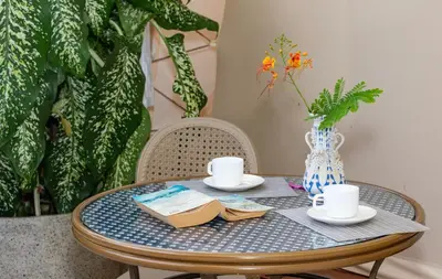 a table with two cups and a book on it at A Slice of Paradise in Sardinal