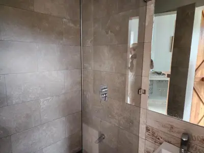 a person taking a picture of a shower in a bathroom at A Slice of Paradise in Sardinal
