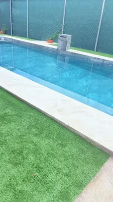 an empty swimming pool with grass around it at Casa Colibrí Playa Blanca in Paquera