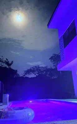 a room with a purple lighted room with a moon at Casa Colibrí Playa Blanca in Paquera